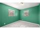 A cozy bedroom features two windows, green walls, and neutral carpet at 5720 Se 20Th St, Ocala, FL 34480