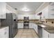 Well-lit kitchen with white cabinets, stainless steel appliances, and granite countertops at 5720 Se 20Th St, Ocala, FL 34480