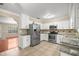 Well-equipped kitchen with stainless steel appliances, granite countertops, and white cabinetry at 5720 Se 20Th St, Ocala, FL 34480