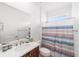 Bathroom with a striped shower curtain and a big mirror above the sink at 5842 Sw 78Th Avenue Rd, Ocala, FL 34474