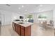 Bright, modern kitchen features a granite countertop island, stainless steel appliances, and open living area at 5842 Sw 78Th Avenue Rd, Ocala, FL 34474