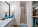 Bright bathroom features a walk-in shower and vanity with a blue countertop and a decorative mirror at 6070 Se 39Th Ave, Ocala, FL 34480
