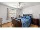 This bedroom features a ceiling fan, wooden furniture, and a window providing natural light at 6070 Se 39Th Ave, Ocala, FL 34480