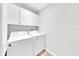 Cozy laundry room featuring white washer and dryer units with storage cabinets above at 6350 Nw 135Th Ave, Morriston, FL 32668