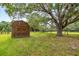 Rustic shed with a weathered exterior, set amidst a picturesque landscape with mature trees and green pastures at 6350 Nw 135Th Ave, Morriston, FL 32668