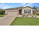 Charming home featuring a stone facade, well-manicured lawn, and a two-car garage at 6405 Sw 88Th Loop, Ocala, FL 34476