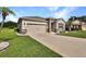 Exterior view of a home, showcasing a two-car garage, stone accents, and a well-kept lawn at 6405 Sw 88Th Loop, Ocala, FL 34476