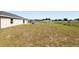 Expansive backyard with lots of green space featuring a fire pit and covered patio at 6561 Sw 129Th Loop, Ocala, FL 34473
