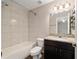 This bathroom includes granite counters, vanity, a large mirror, and a shower-tub combo with tiled walls at 6561 Sw 129Th Loop, Ocala, FL 34473