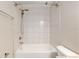 Bright white bathtub with tiled walls and sleek shower fixtures, complemented by a modern toilet at 6561 Sw 129Th Loop, Ocala, FL 34473