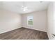 This bedroom includes wood-look flooring, neutral walls, a ceiling fan, and a window with blinds at 6561 Sw 129Th Loop, Ocala, FL 34473
