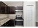 Modern kitchen featuring stainless steel oven, granite countertops, and dark cabinetry at 6561 Sw 129Th Loop, Ocala, FL 34473