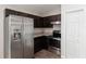Modern kitchen boasts stainless steel appliances and dark cabinets, next to white pantry at 6561 Sw 129Th Loop, Ocala, FL 34473