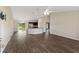 Spacious open-concept living room with hardwood floors, modern ceiling fan and access to kitchen at 6561 Sw 129Th Loop, Ocala, FL 34473