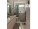 Well-lit bathroom with a single sink vanity, tiled floor, and a walk-in shower for easy accessibility at 7251 Sw 115Th Pl, Ocala, FL 34476