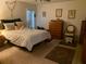 Serene bedroom featuring soft carpet, a comfortable bed with plush pillows, and traditional wooden furniture at 7251 Sw 115Th Pl, Ocala, FL 34476