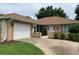 Charming single-story home featuring an attached garage, manicured landscaping, and a welcoming front entrance at 7251 Sw 115Th Pl, Ocala, FL 34476