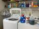 Laundry room with a washing machine and dryer, along with shelving for storage and laundry supplies at 7251 Sw 115Th Pl, Ocala, FL 34476