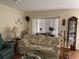 Cozy living room featuring a floral sofa, wood floors, and a large bay window that brings in natural light at 7251 Sw 115Th Pl, Ocala, FL 34476