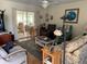 Comfortable living room with wood floors, a large rug, and access to the sunroom through sliding glass doors at 7251 Sw 115Th Pl, Ocala, FL 34476