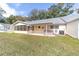 View of the backyard featuring a lawn and a covered patio with a hot tub and air conditioning unit at 8420 Sw 93 Ln # E, Ocala, FL 34476