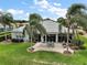 Aerial view of backyard patio with furniture, lush landscaping, and a well-maintained lawn at 8772 Se 130Th Loop, Summerfield, FL 34491