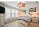 Bright bedroom features a ceiling fan, natural light, and neutral decor for relaxation at 8772 Se 130Th Loop, Summerfield, FL 34491