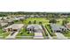 Aerial view of single-Gathering home showcasing lush landscaping, a well-manicured lawn, and a three-car garage at 8772 Se 130Th Loop, Summerfield, FL 34491
