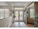 Inviting foyer featuring glass double doors, wood floors, and a rustic sliding barn door at 8772 Se 130Th Loop, Summerfield, FL 34491
