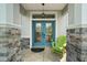 Charming entrance with a decorative double door, stone accents, and a welcoming green chair at 8772 Se 130Th Loop, Summerfield, FL 34491