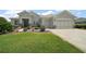Charming single Gathering home with a lush lawn, beautiful landscaping, decorative stone and a blue front door at 8772 Se 130Th Loop, Summerfield, FL 34491