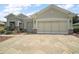 Attached two car garage with decorative stone trim and large decorative driveway pavers at 8772 Se 130Th Loop, Summerfield, FL 34491