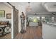 Open-concept space with barn door, suit of armor, and chandelier which leads to the the bright living room at 8772 Se 130Th Loop, Summerfield, FL 34491