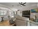 Well-lit living room with a large TV, comfortable seating, and a view of other rooms in the home at 8772 Se 130Th Loop, Summerfield, FL 34491