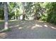 Home's backyard showing greenery and open space. Sheds and miscellaneous items in the background at 1050 E Highway 329, Citra, FL 32113