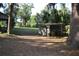 Backyard with a tractor, greenery, and a storage building. Spanish moss on trees at 1050 E Highway 329, Citra, FL 32113