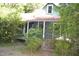 Charming one-and-a-half story home with a covered front porch nestled amongst lush greenery at 1050 E Highway 329, Citra, FL 32113