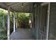 View of exterior porch needing repair with foliage at 1050 E Highway 329, Citra, FL 32113