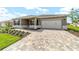 Inviting one-story home with brick-paved driveway, white garage door, and well-kept lawn at 10562 Sw 96Th Lane Rd, Ocala, FL 34481