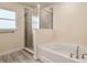 Well-lit bathroom showcases a tub with shower and contemporary design with tile surround at 10910 Sw 41St Ave, Ocala, FL 34476