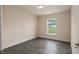 Bright bedroom featuring gray wood-look flooring, light neutral walls, and a sunlit window at 10910 Sw 41St Ave, Ocala, FL 34476
