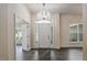 Foyer with wood-look tile flooring, chandelier, and sidelights around the front door for extra brightness at 10910 Sw 41St Ave, Ocala, FL 34476