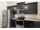 Modern kitchen with stainless steel appliances and dark cabinetry at 10910 Sw 41St Ave, Ocala, FL 34476