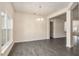 Spacious living room features wood-look tile, neutral walls, and a stylish chandelier for a modern touch at 10910 Sw 41St Ave, Ocala, FL 34476