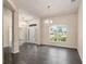 Bright living room features elegant chandeliers, wood-look tile flooring, and a large window with a pleasant view at 10910 Sw 41St Ave, Ocala, FL 34476