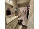 Cozy bathroom with white vanity, matching cabinets, and shower featuring decorative floral accents at 11412 Sw 51St Cir, Ocala, FL 34476