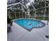 Screened-in pool area with clear blue water, surrounding trees and patio space for outdoor enjoyment at 11412 Sw 51St Cir, Ocala, FL 34476