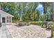 Relaxing brick back patio with outdoor seating, grill, and a peaceful view of the fenced backyard with mature trees at 12677 Se 53Rd Terrace Rd, Belleview, FL 34420