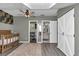 Well-lit Bedroom featuring wainscoting, a crib, and gray wood floors with adjacent rooms at 12677 Se 53Rd Terrace Rd, Belleview, FL 34420