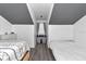 Cozy bedroom featuring two beds, wood-look floors, and a gray accent on the vaulted ceiling at 12677 Se 53Rd Terrace Rd, Belleview, FL 34420